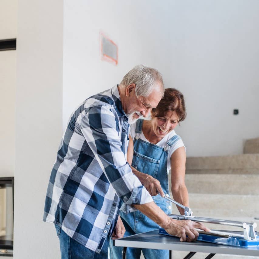 Old man and woman working on interior of new house or flat.